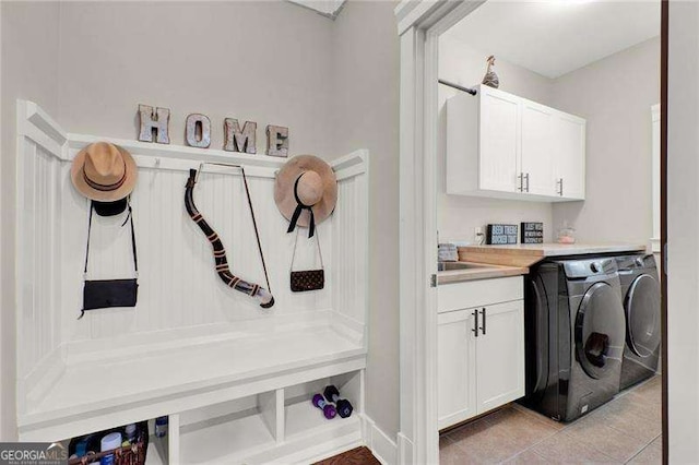 washroom with light tile patterned floors, cabinet space, and separate washer and dryer