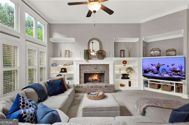 living area with ornamental molding, a fireplace, a ceiling fan, and built in features