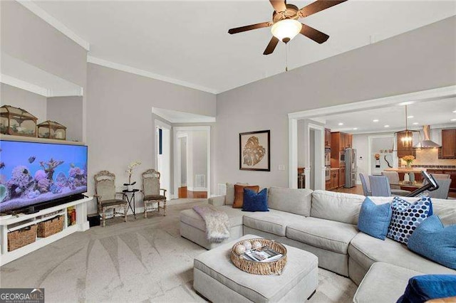 living area featuring light carpet, ceiling fan, ornamental molding, and recessed lighting