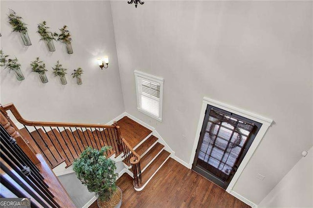 foyer entrance featuring stairway, wood finished floors, and baseboards