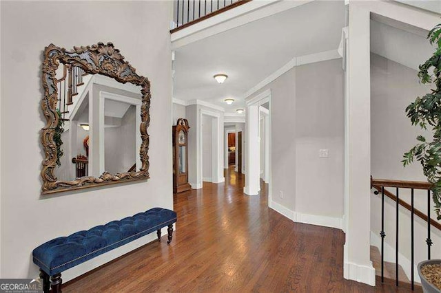 corridor featuring stairs, crown molding, baseboards, and wood finished floors