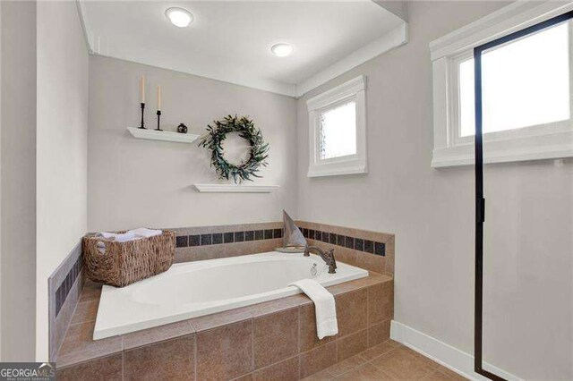 bathroom featuring a garden tub, baseboards, visible vents, and tile patterned floors