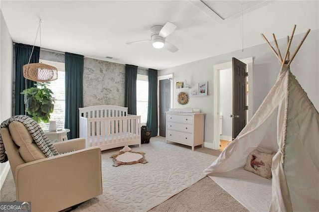 carpeted bedroom featuring attic access, baseboards, and ceiling fan