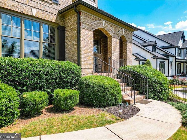 entrance to property featuring brick siding