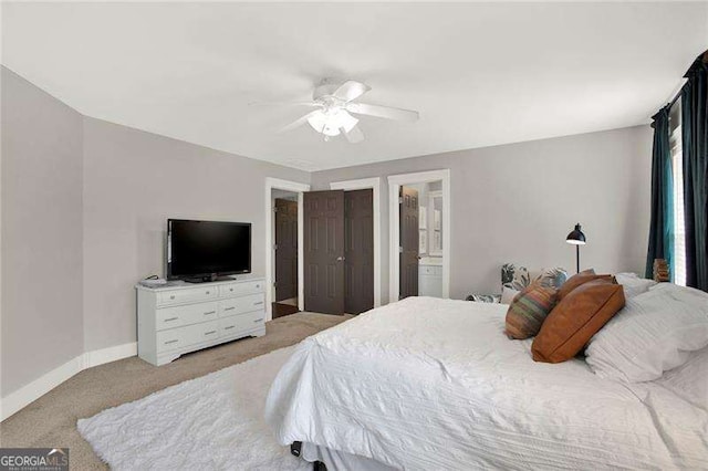 bedroom with light carpet, ceiling fan, ensuite bath, and baseboards