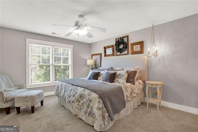 bedroom with carpet floors, visible vents, baseboards, and ceiling fan with notable chandelier