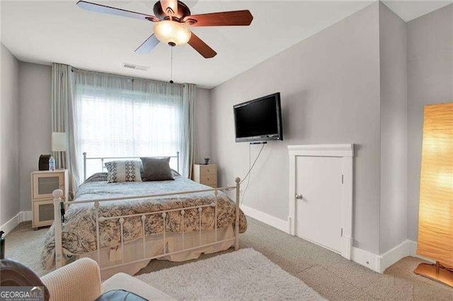 carpeted bedroom featuring a ceiling fan, visible vents, and baseboards