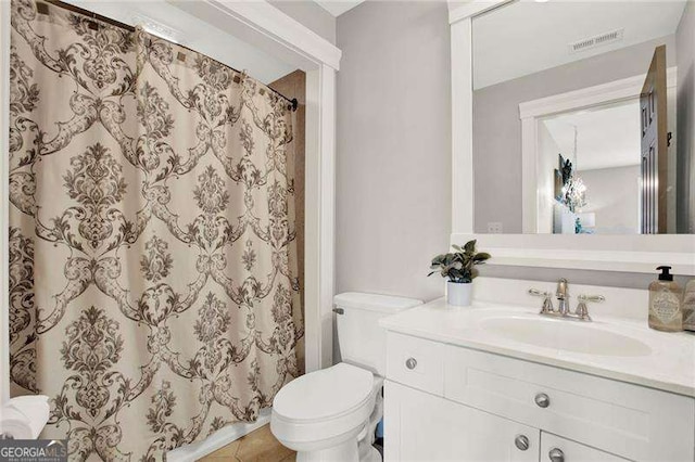 bathroom featuring toilet, a shower with curtain, visible vents, and vanity