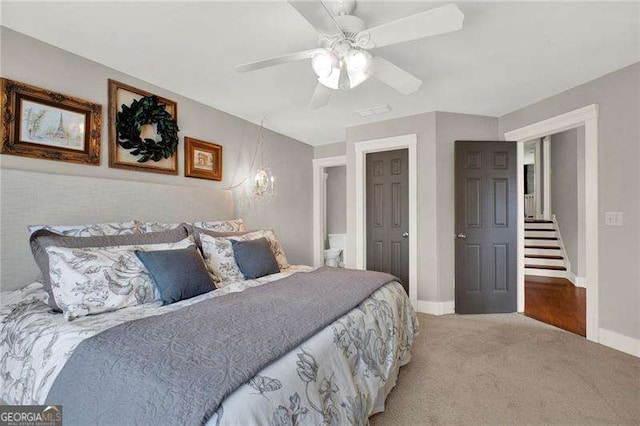 carpeted bedroom with ceiling fan and baseboards