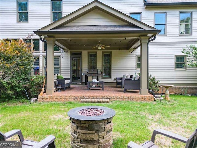 back of house featuring a yard, an outdoor fire pit, ceiling fan, and a patio