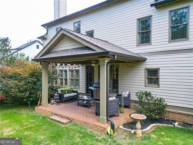 rear view of property with a chimney, an outdoor living space, and a lawn