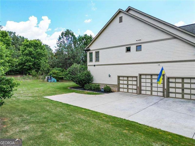 view of home's exterior with concrete driveway, a lawn, and an attached garage