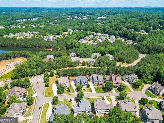 aerial view featuring a forest view, a water view, and a residential view