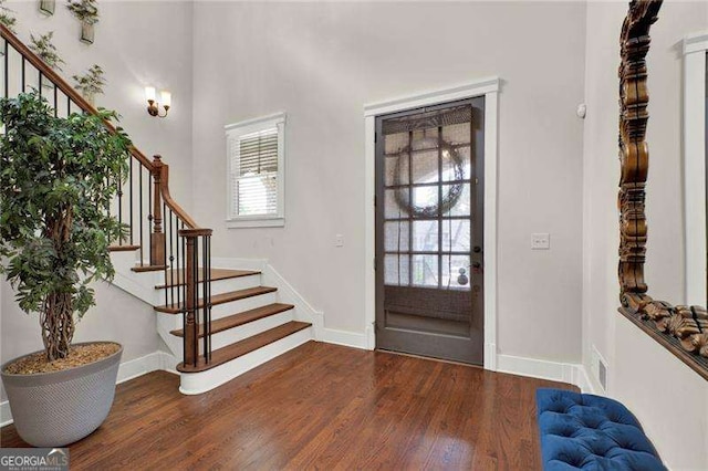 entryway with baseboards, visible vents, stairway, and wood finished floors