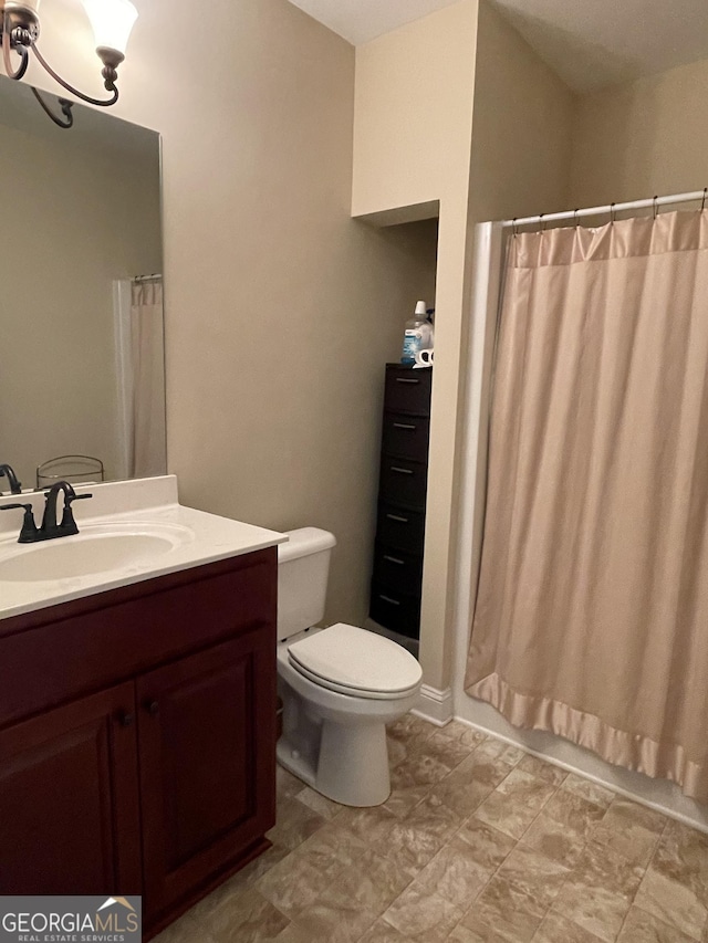 bathroom with vanity, curtained shower, and toilet