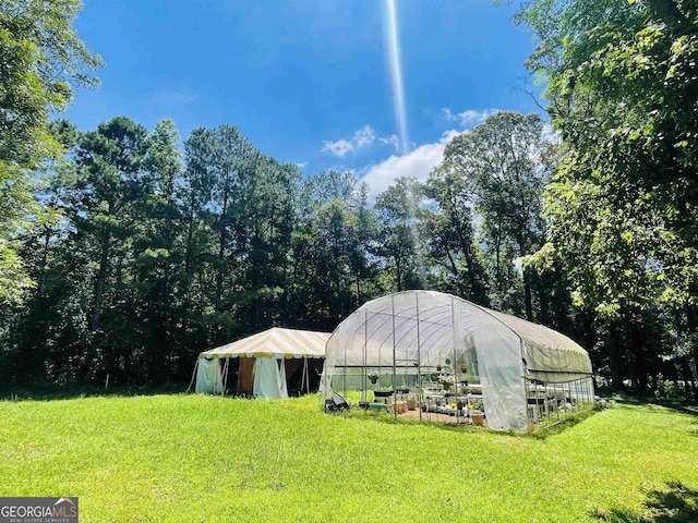 view of greenhouse featuring a yard