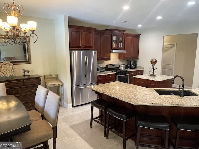 kitchen featuring a sink, a center island, recessed lighting, appliances with stainless steel finishes, and glass insert cabinets