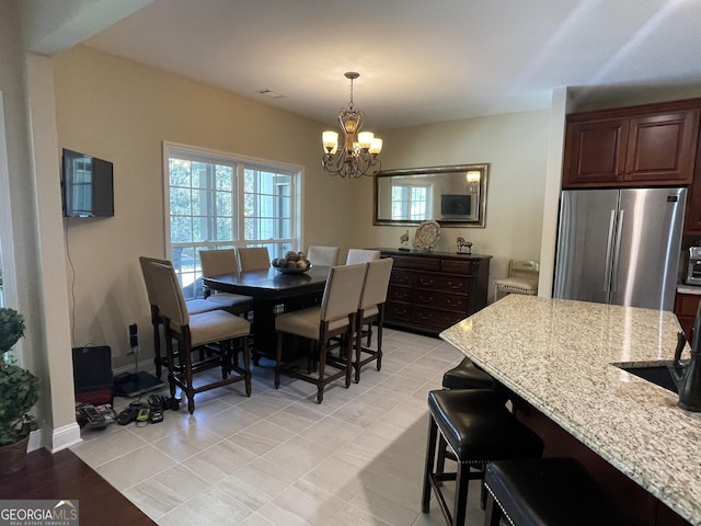 dining room featuring an inviting chandelier, baseboards, and visible vents