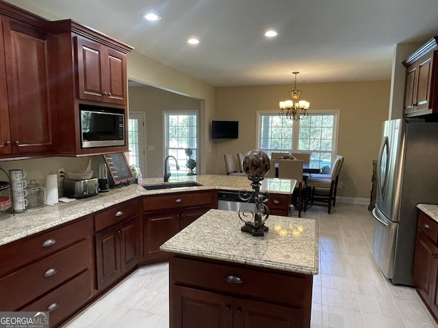 kitchen featuring a peninsula, recessed lighting, a sink, appliances with stainless steel finishes, and a notable chandelier