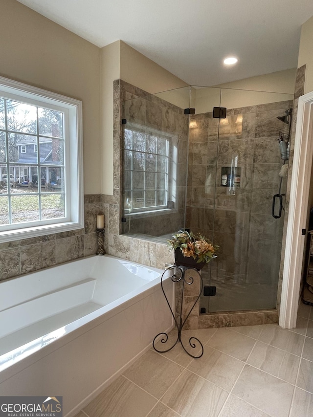 full bathroom featuring a stall shower, a bath, and tile patterned floors