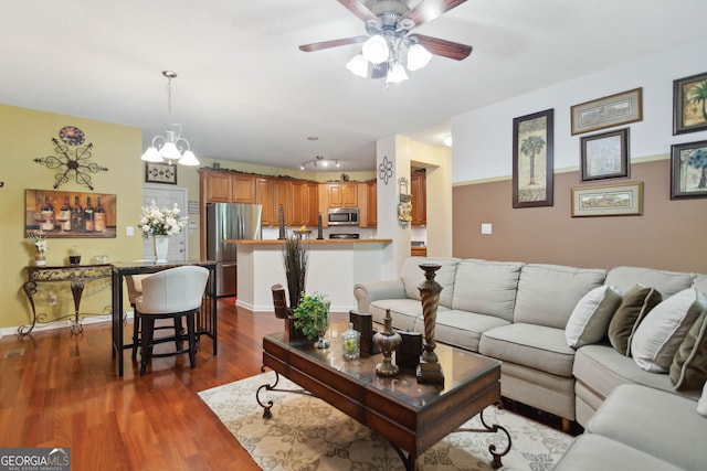 living room featuring dark wood-style flooring, ceiling fan, and baseboards