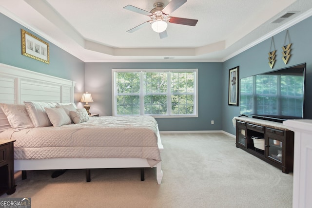 carpeted bedroom with ceiling fan, baseboards, visible vents, and a raised ceiling