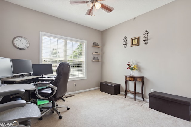 carpeted office space with ceiling fan and baseboards