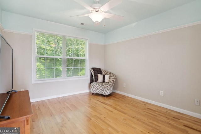 unfurnished room featuring a ceiling fan, visible vents, baseboards, and wood finished floors