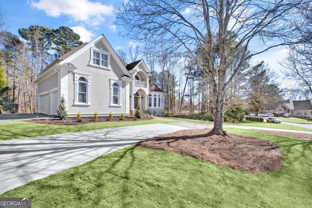 view of front of property with aphalt driveway, a front lawn, and stucco siding