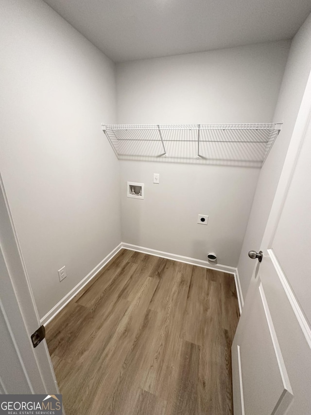 laundry area featuring hookup for a washing machine, hookup for an electric dryer, wood finished floors, laundry area, and baseboards