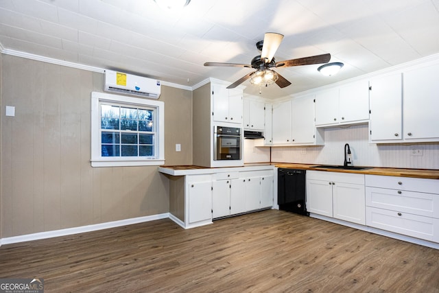 kitchen featuring wall oven, black dishwasher, wood finished floors, a wall mounted air conditioner, and a sink