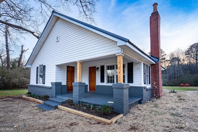 view of front of property featuring covered porch and a chimney