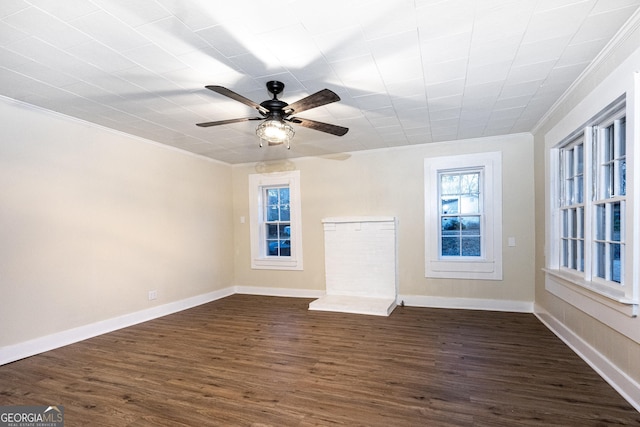 unfurnished living room featuring a ceiling fan, baseboards, ornamental molding, and dark wood-style flooring