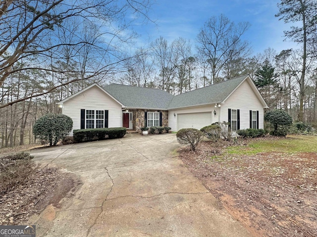 single story home featuring a garage, stone siding, and driveway