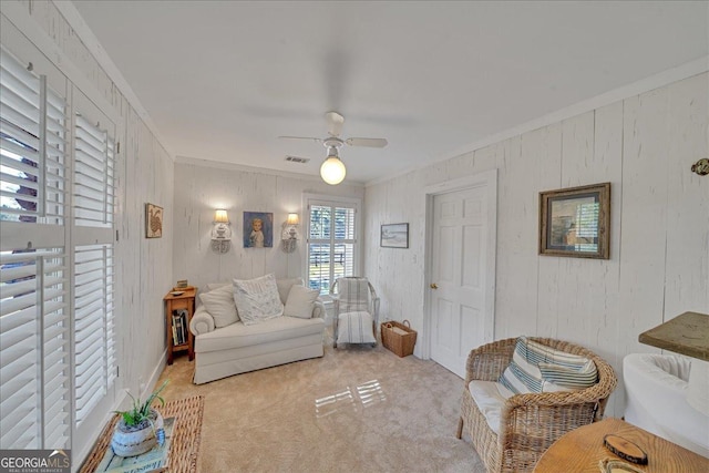 interior space featuring a ceiling fan, light carpet, crown molding, and visible vents