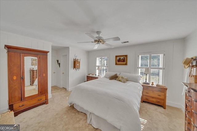 bedroom with light colored carpet, visible vents, ceiling fan, and baseboards