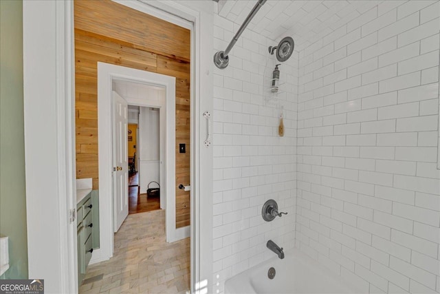 full bath with shower / bath combination, wood walls, and vanity