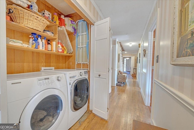 laundry room featuring laundry area, light wood-type flooring, and washing machine and clothes dryer