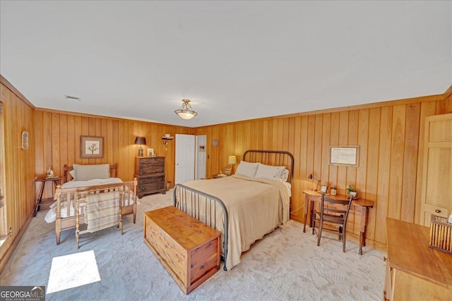 carpeted bedroom featuring wooden walls and visible vents