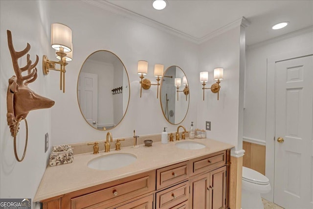 bathroom with double vanity, ornamental molding, a sink, and toilet