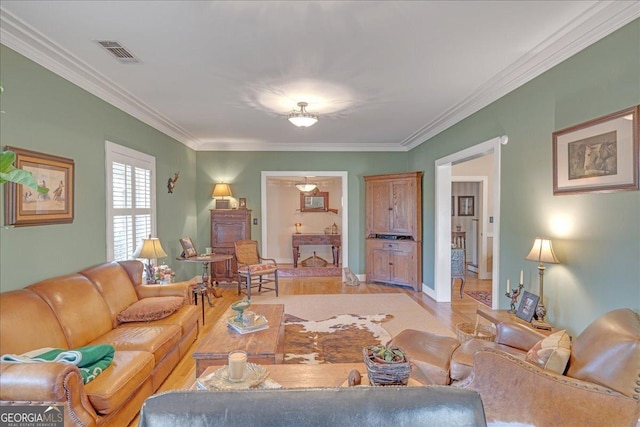 living area featuring baseboards, visible vents, and crown molding