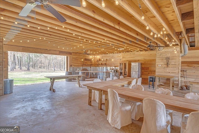 unfurnished dining area with concrete floors, wood walls, and ceiling fan