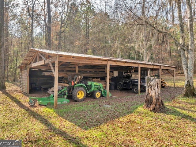 view of pole building featuring a forest view and a carport