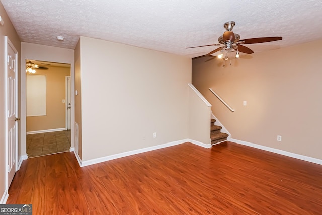 interior space featuring baseboards, a textured ceiling, stairway, and wood finished floors