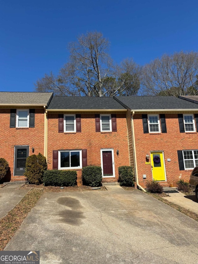 view of front of property with brick siding and a shingled roof