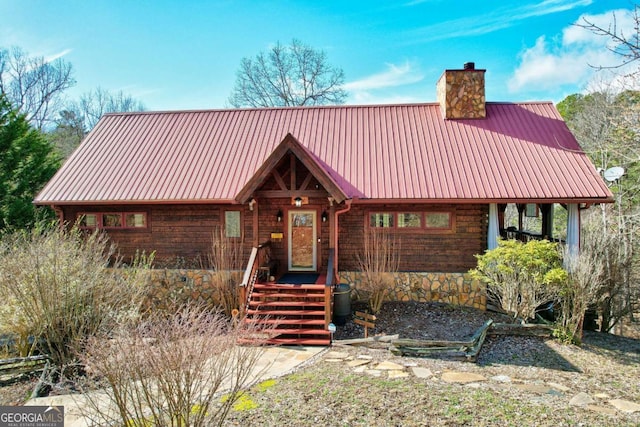 view of front of house with metal roof and a chimney