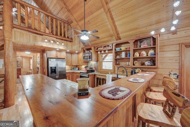 kitchen featuring appliances with stainless steel finishes, beamed ceiling, butcher block countertops, and wood ceiling