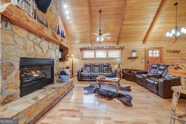 living area featuring a stone fireplace, beamed ceiling, wooden ceiling, and wood finished floors