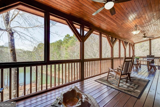 sunroom / solarium featuring a ceiling fan, wood ceiling, and a healthy amount of sunlight