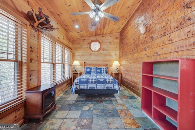 bedroom featuring lofted ceiling, wooden ceiling, wood walls, and stone finish flooring